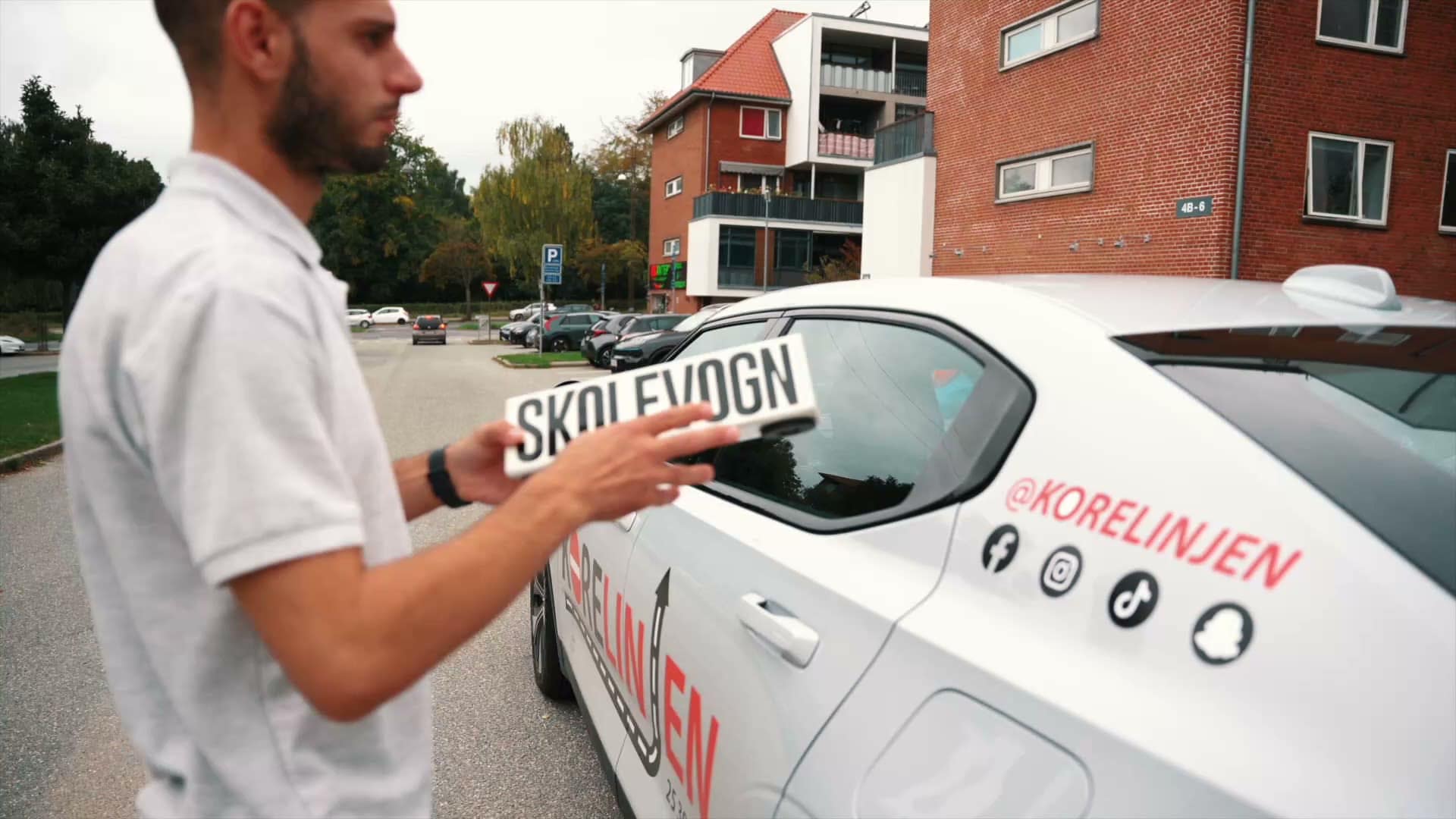 Sabah sætter skolevogn-skiltet på taget af Kørelinjens bil